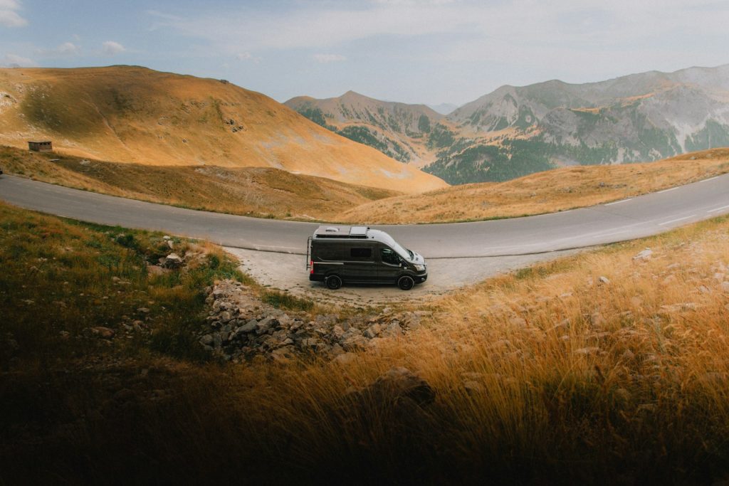Van aménagé roulant sur une route de montagne, illustration d'un trajet en van life connecté via Starlink