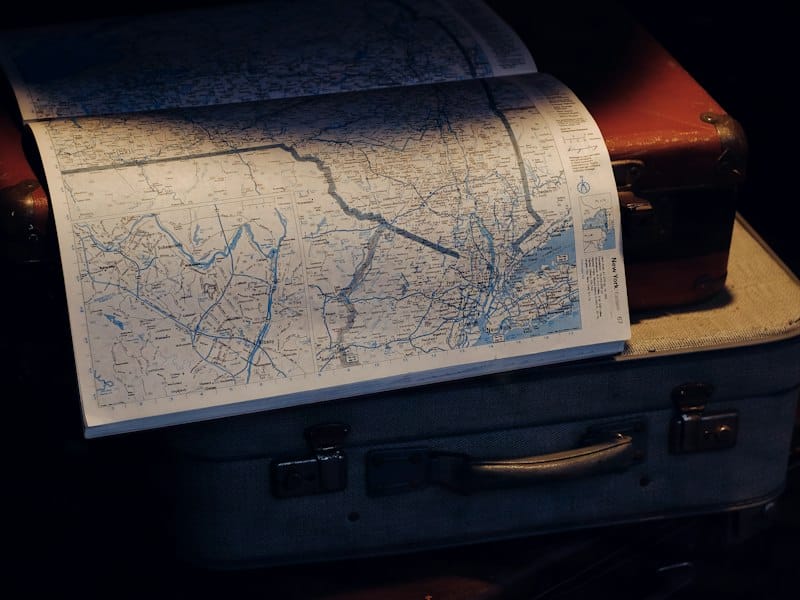 Deux valises posées sur une carte du monde dépliée, pour illustrer le choix d'une eSIM de voyage